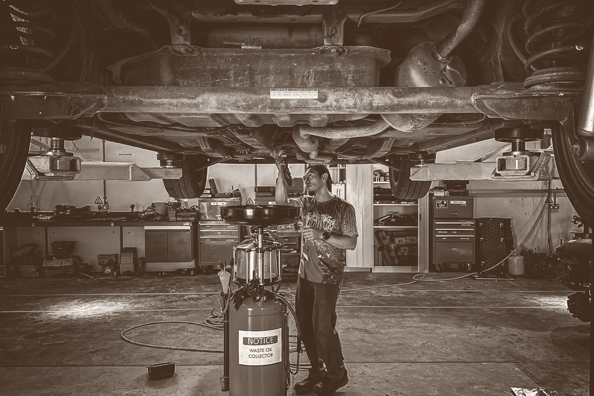 A mechanic working under a car in a repair shop