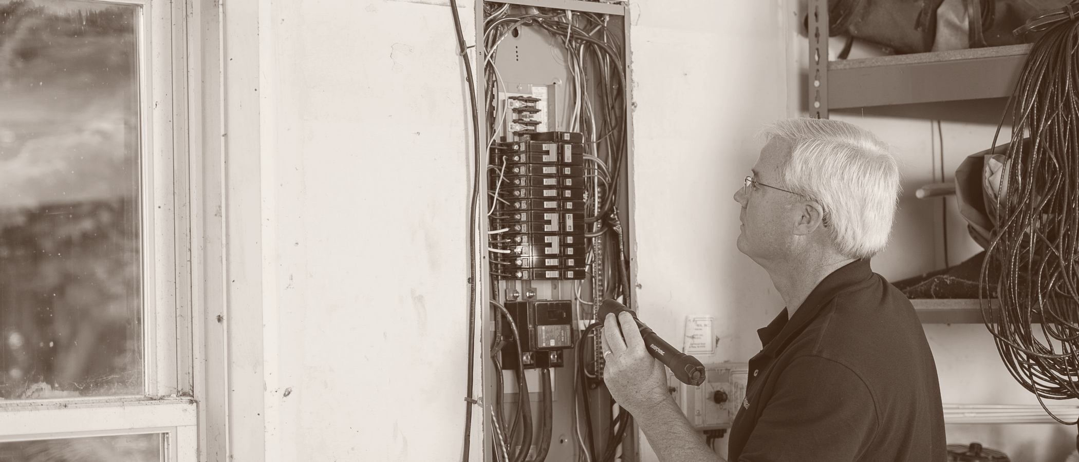 Electrician working at an open service panel