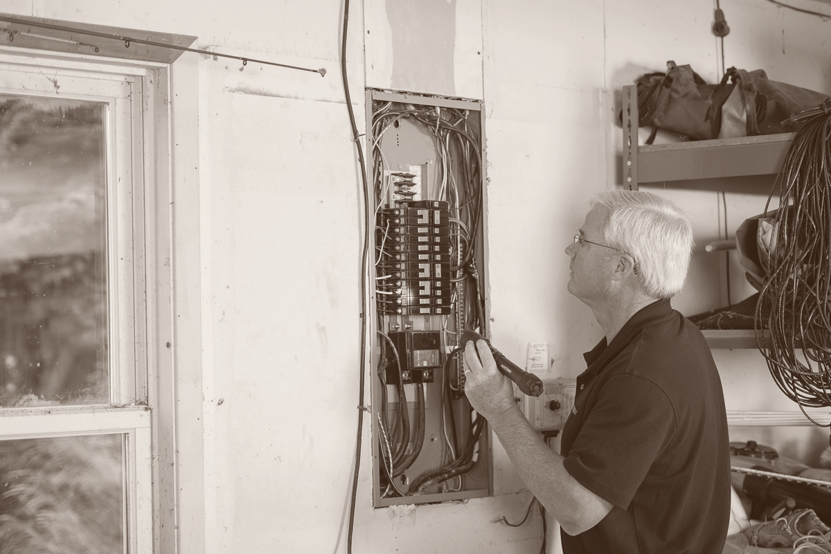 An electrician wiring an electrical panel on site